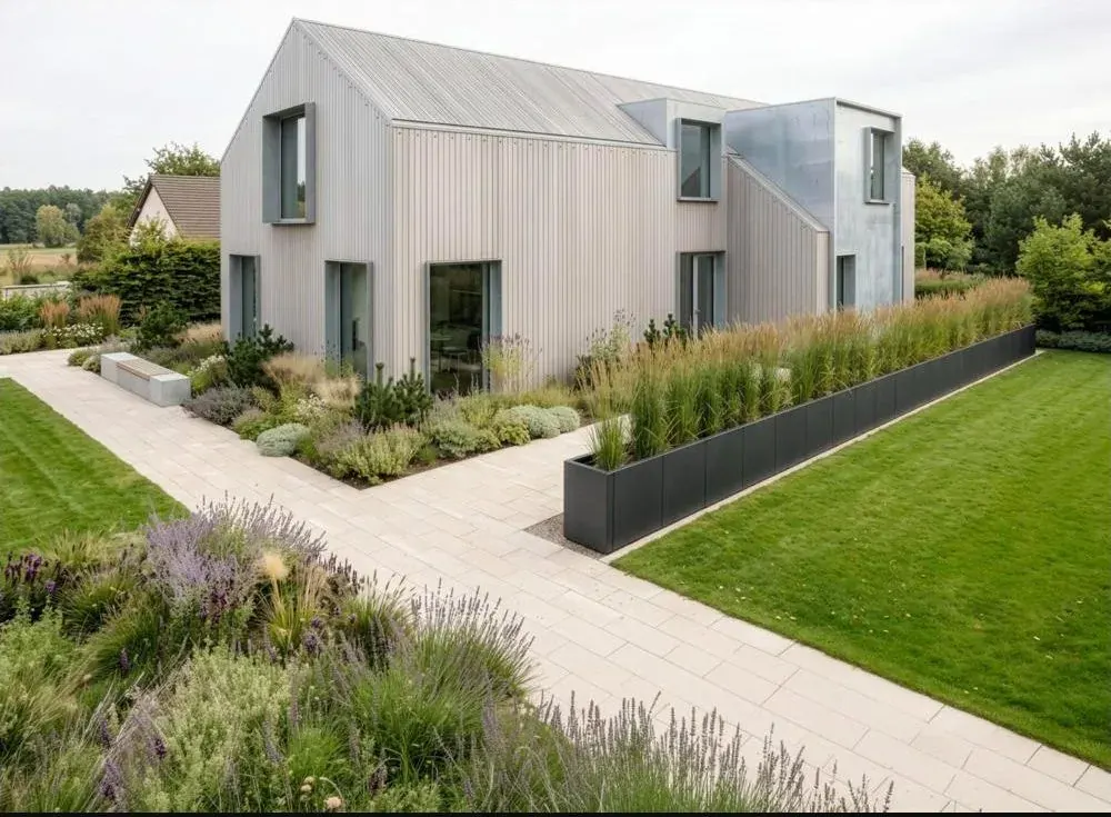 Langes modulares Hochbeet in Anthrazit entlang eines Gartenwegs vor einem modernen Haus